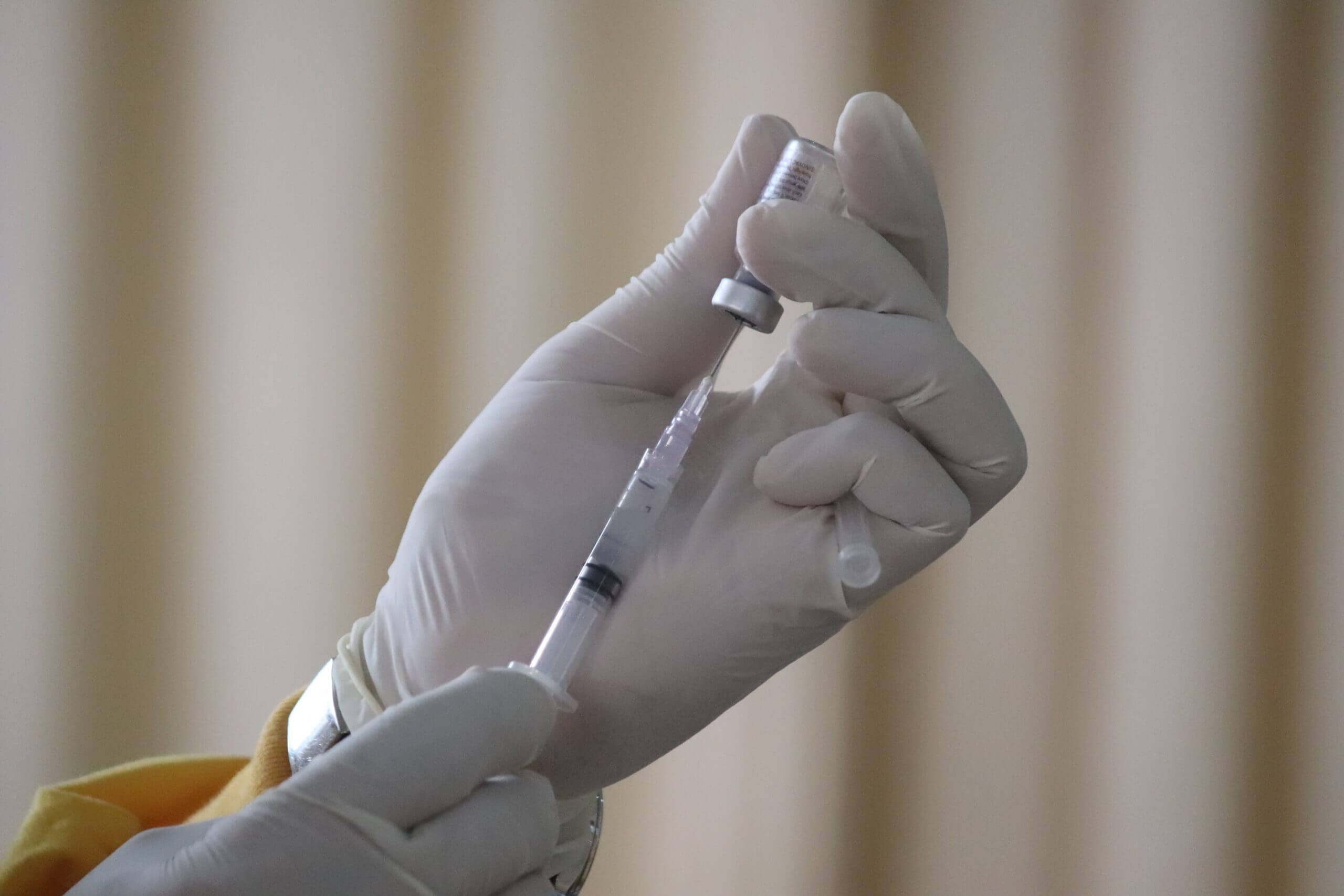 Photo montrant deux mains préparant une seringue pour la vaccination